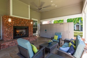 One Bedroom Apartments for Rent in Conroe, TX - Covered Outdoor Seating Area with lit Fireplace & Package Hub   